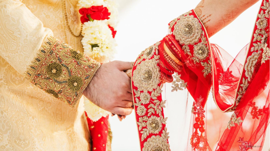 Bride and groom holding hands in traditional attire